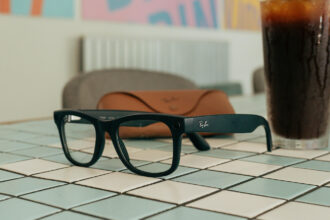Lunettes RayBan IA posées à côté d'un verre de Coca